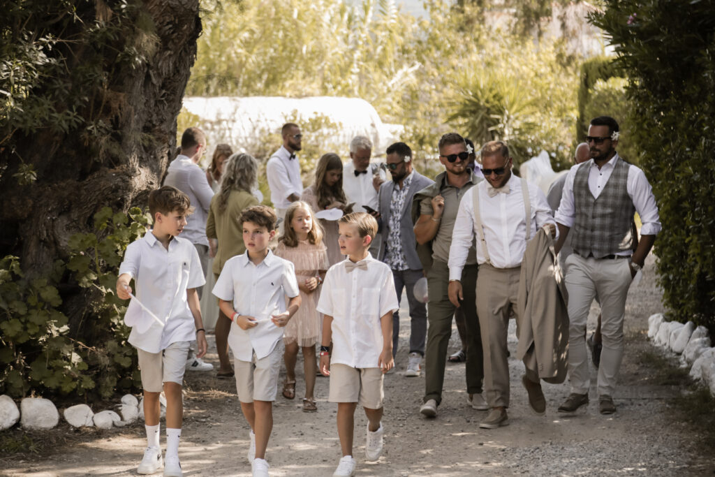 Hochzeitsgäste auf dem Weg zur Trauzeremonie am Strand auf Kreta in Griechenland.