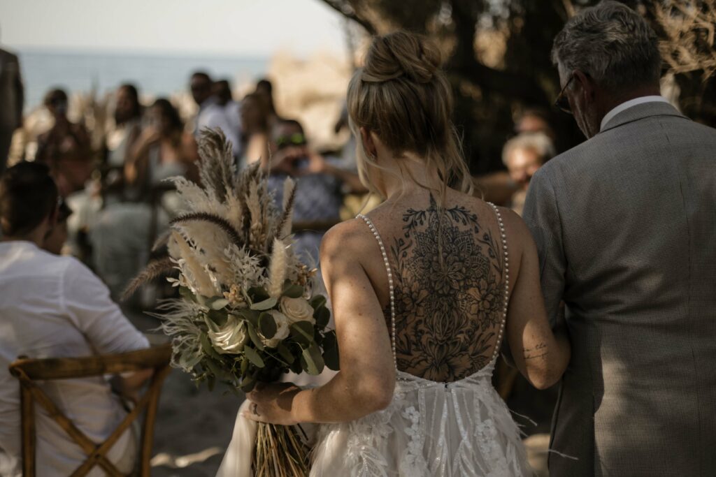 Braut gefürt vom Vater zur Trauung am Strand auf Kreta in Griechenland