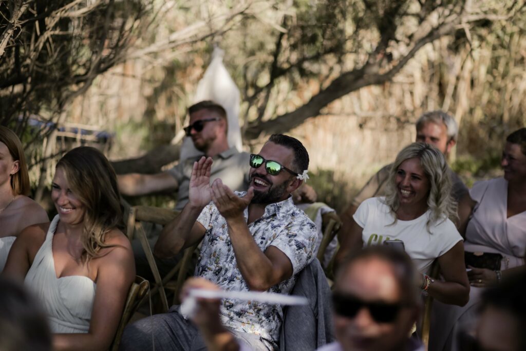 Lachende Gäste applaudieren bei freier Trauung am Sttrand auf Kreta