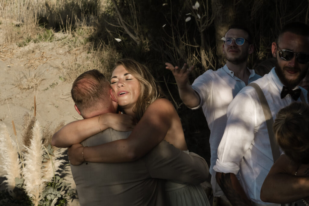 Gäste gratulieren Brautpaar nach symbolischer Strand-Hochzeit auf Kreta in Griechenland