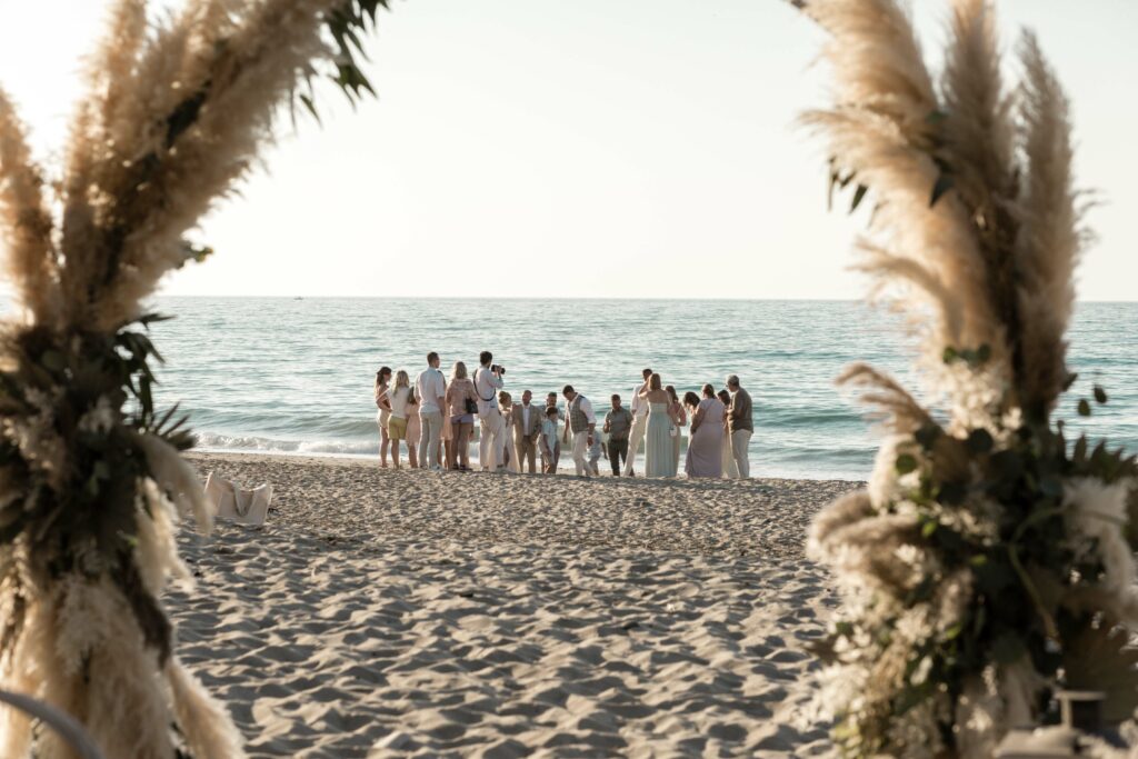 Fotoshooting am Strand mit den Hochzeitsgästen auf Kreta hinterm Traubogen