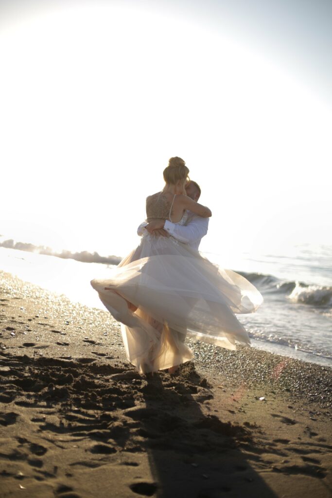Brautpaar tanzt ei Fotoshooting am Meer nach Trau-Zeremonie am Strand