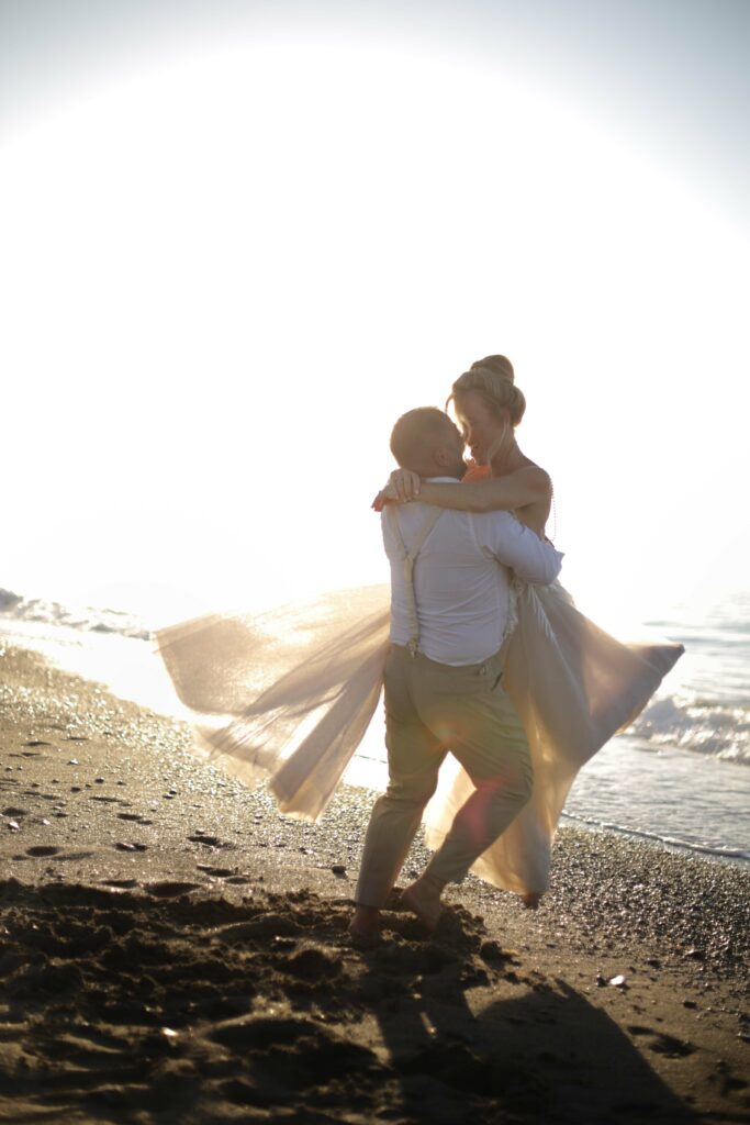 Braut und Bräutigam tanzen am Meer nach Hochzeit