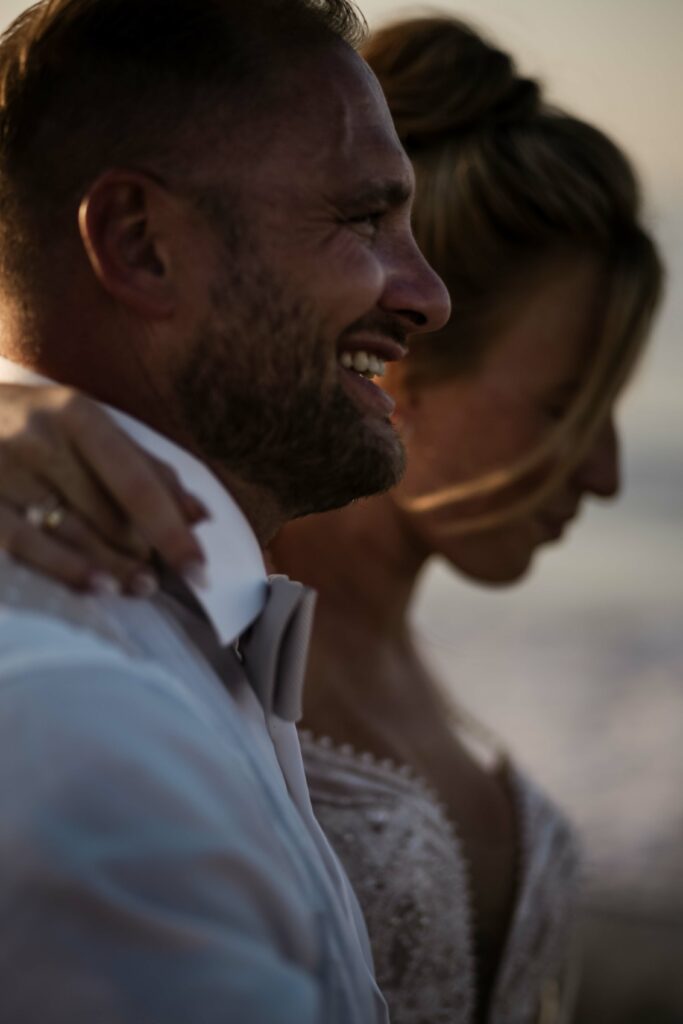 Bräutigam lacht bei Fotoshooting nach Trauung am Strand bei Rethymno auf Kreta